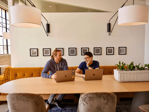 Two researchers working together on laptops